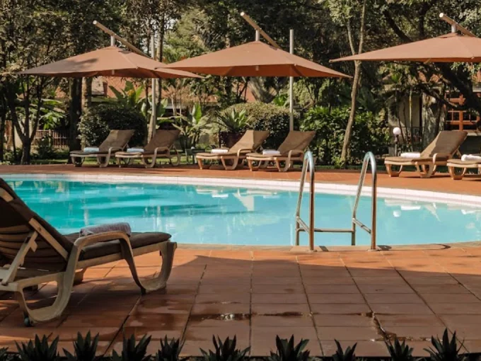 The inviting swimming pool at Arusha Planet Lodge, surrounded by lush gardens and offering a relaxing oasis for guests in Tanzania, perfect for unwinding after a day of safari adventures.